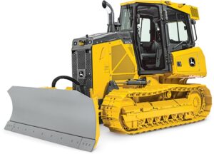 A yellow John Deere 650 dozer with a plow attachment on a white background. Dozers are powerful tracked vehicles used for pushing large amounts of dirt or other materials. This John Deere dozer has a yellow exterior with black tracks, a large blade at the front, and a plow attachment for clearing snow or other debris. There are markings on the side that include "John Deere" and "650"