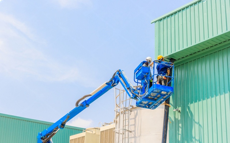Boom lift accessing rooftop for maintenance.