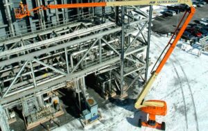 125ft Articulating Boom Lift providing elevated access for industrial plant maintenance and structural work during winter conditions.