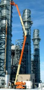 125ft Articulating Boom Lift reaching tall industrial processing towers for high-access maintenance and inspection work.