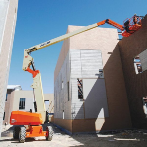 80ft Articulating Boom Lift performing exterior masonry and maintenance work between commercial buildings under clear blue skies.