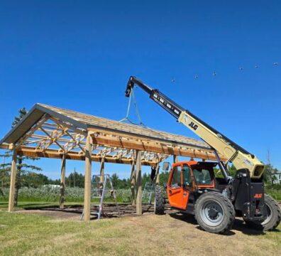 Telehandler lifting roof trusses during construction to improve jobsite efficiency and streamline material handling.