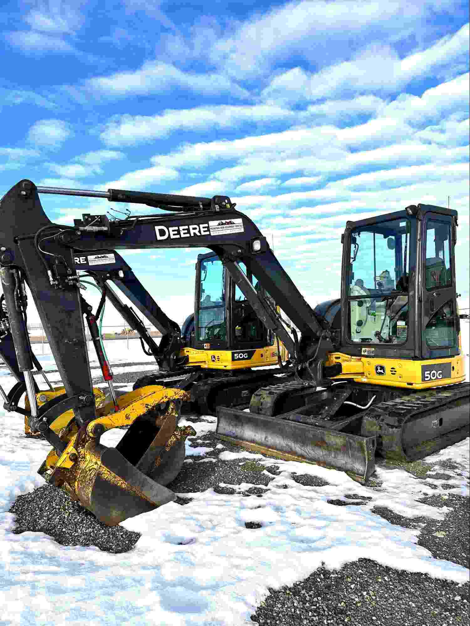 Two 5-tonne mini excavators on a job site, illustrating small excavator rental costs and equipment options for construction projects.