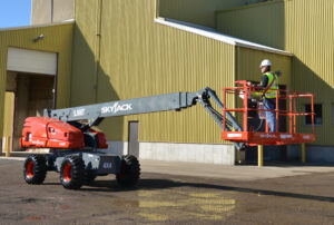66ft Telescopic / Straight Boom Lift operated by a worker performing elevated maintenance work at an industrial facility.