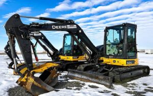 Two 5-tonne mini excavators on a job site, illustrating small excavator rental costs and equipment options for construction projects.