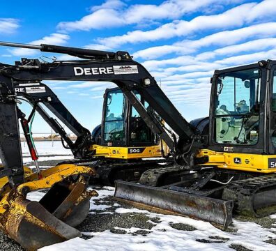 Two 5-tonne mini excavators on a job site, illustrating small excavator rental costs and equipment options for construction projects.
